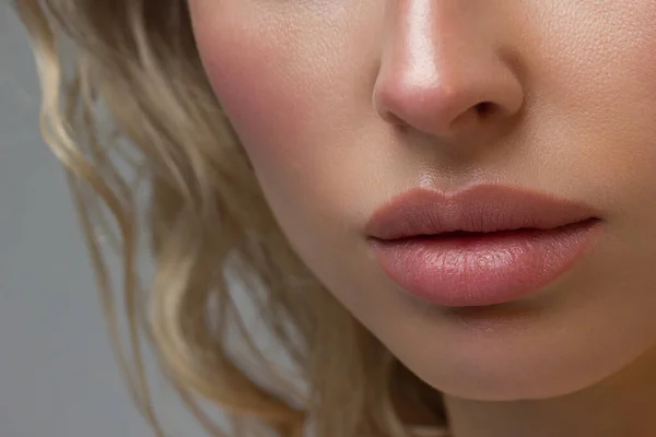 Close-up of woman\'s Lips with Fashion pink Make-up and Manicure on Nails. Beautiful female full lips with perfect Makeup. Part of female face. Macro shot of beautiful make up on full lips