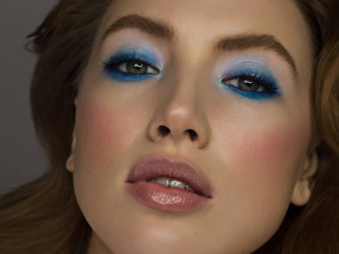 Bir kadının yarım yüz güzelliği sparkles yaratıcı moda makyaj ile Close-up. Siyah eyeliner ve uzun kirpiklerini ela gözlü ve dudakları eşleşecek şekilde süsleyin. Spa sonra bakımlı cilt
