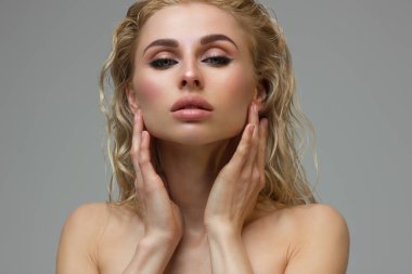 Parlak makyajlı, seksi kırmızı çizgili güzel bir kadın. Kadının göz kapağında büyük bir ok şekli var. Doğal dudaklar. Şık bir akşam makyajı. Lüks uzun dalga saçı. Parlak yüz derisi