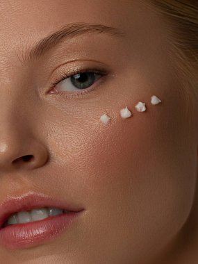 Güzel surat. Temiz Taze Cildi olan Güzel Genç Kadın kendi yüzüne ve vücuduna dokunuyor. Yüz bakımı. Kozmetik, güzellik ve kaplıca konsepti