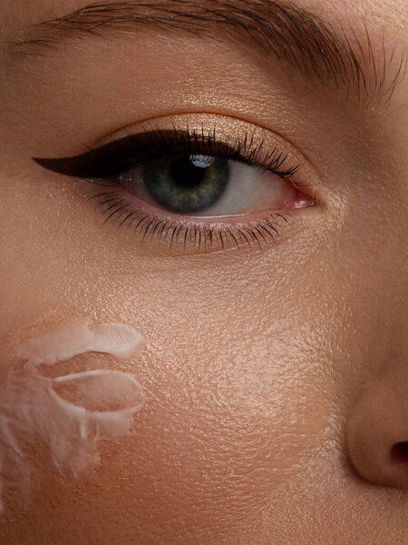 Закрытие лица красивой женщины с идеальной кожей благодаря кремам для поддержания молодости и кремовому контуру против старения и морщин глаз. Концепция красоты, чистоты и совершенства