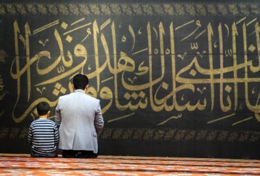 Istanbul, Türkiye - 21 Ekim: Arapça hat, Istanbul, Türkiye'de 21 Ekim 2018 üzerinde Sultanahmet Camii önünde dua Müslümanlar. 17. yüzyılda Mimar Mehmet Ağa tarafından inşa Sultanahmet Camii.