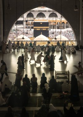 MECCA, SAUDI ARABIA - JANUARY 28: Muslim pilgrims from all around the World revolving around the Kaaba on January 28 2017 in Mecca Saudi Arabia. Muslim people praying together at holy place. clipart