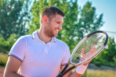 Genç adam tenis oynuyor.