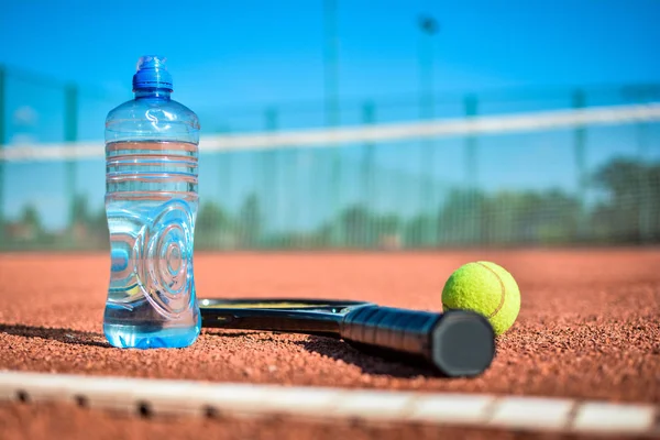 テニスボール ラケット 粘土裁判所上の水のボトル — ストック写真