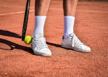 Genç adam tenis oynuyor.