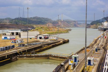 Panama Kanalı, 03/11/2016, çıkış ilk kilidi. Centennial köprü önde. Resmi ağ geçidi engelleri ve Panama Kanalı'nın araçları gösterir. Centennial köprünün Panama Kanalı geçiş ikinci ana yol oldu önde gidiyor, 