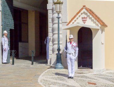 Monaco, 06/14/2012, gardiyan Prens'in Sarayı'nda onur. Şeref kıtası tribünde beyaz memurları giymiş. Bekçi, Prens Sarayı'nın duvarları değişen güzel tören birçok turistlerin ilgisini çekmektedir..