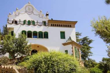Barselona, İspanya, 06/15/2012, Gaudi park Triyas ev. Beyaz art Nouveau tarzında inşa sevimli yeşil ağaçların çok güzel görünüyor.