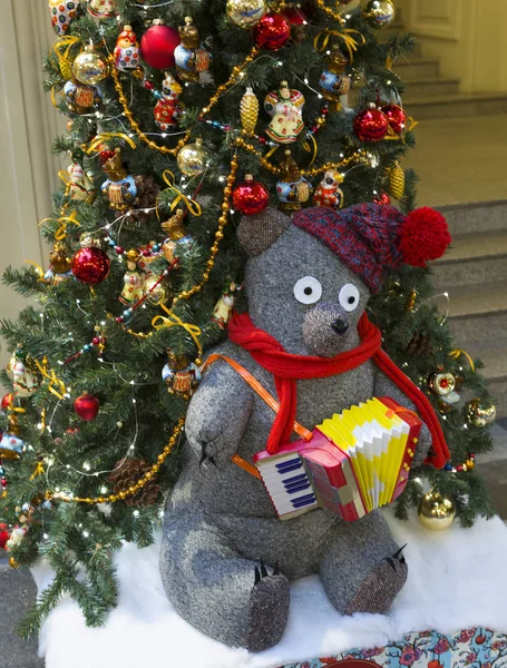 Toy bear under the Christmas tree. Magic, fabulous new year\'s holiday each person is associated with a Christmas tree decorated with Christmas toys.