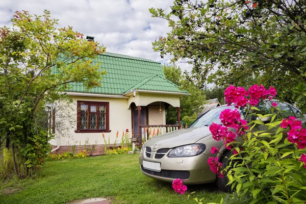 Kır evi. Ahşap yazlık evinde banliyölerinde çiçek ve meyve çalılar çevrili bir yaz gününde.