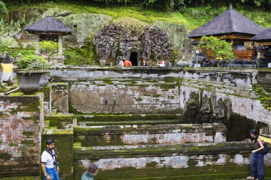 Bali, Endonezya, 01/11/2018, Ubud. Fil Goa Gaja mağara. Fil Mağarası önünde topraklarında vardır iki Yüzme Havuzu (Hamam), altın sazan, erkek ve kadın, taş ve toprak kayalar moss ile büyümüş.