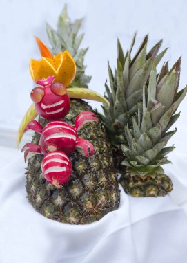 Ananas, oyma tekniğiyle süslenmiş. Yemek pişirme sanatında sebze ve meyve kesme sanatıdır. Yemek oymacılığında yapılan yemekler için süslemeler..