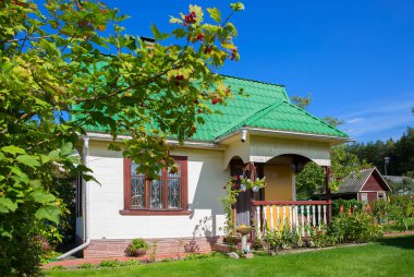 Yeşil çimenlikteki kır evi. Şehrin yaz sakinleri için küçük bir ev..