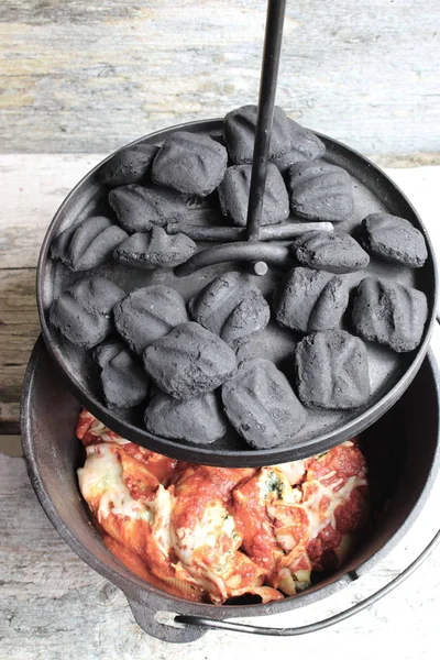 練炭の鋳鉄製ダッチ オーブン パスタの夕食 ストックフォト