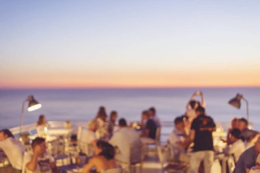 bir restoran günbatımı güzel sahne ile tepenin üstüne oturan tanınmayan insanlar arka plan bulanıklık 
