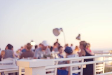 bir restoran günbatımı güzel sahne ile tepenin üstüne oturan tanınmayan insanlar arka plan bulanıklık 