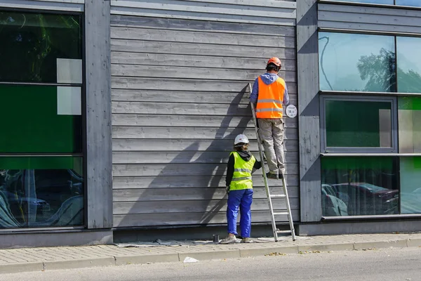 two workers paint the wall