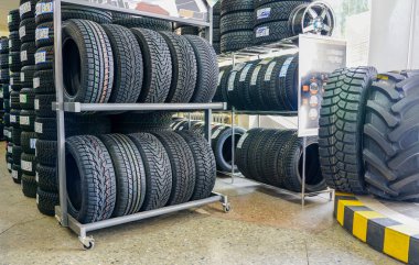 a lot of new modern winter tires, tire shop in the background clipart