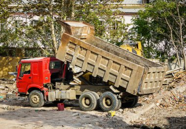 İnşaat alanında bir büyük yükseltilmiş gövdeli kırmızı Damperli kamyon