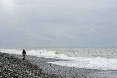 Karadeniz, arkadan görünüm, bulutlu hava sahil boyunca yürüyen yalnız adam