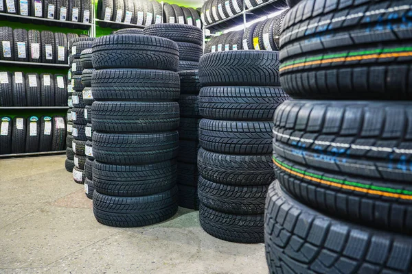 Bastidor con variedad de neumáticos de coche nuevos en la tienda de automóviles —  Fotos de Stock