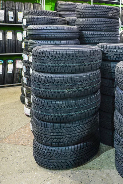 Bastidor con variedad de neumáticos de coche nuevos en la tienda de automóviles — Foto de Stock
