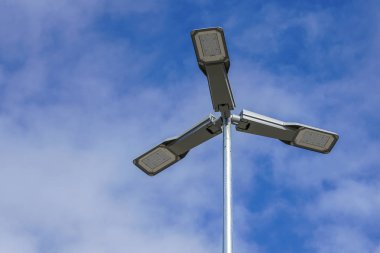 Üç LED sokak lambaları derin bir mavi gökyüzüne karşı demir bir yazı yapıştırılmış