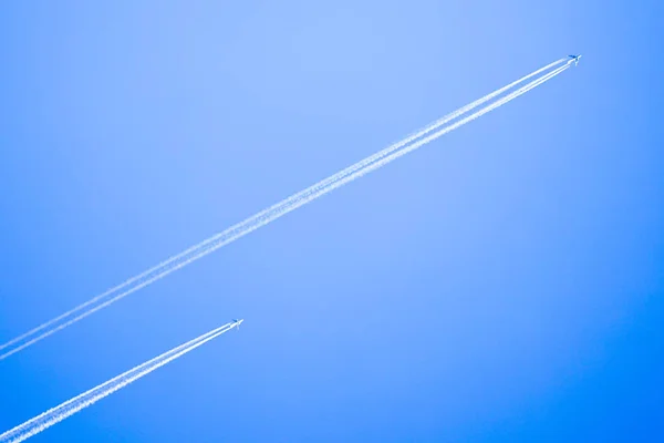 Δύο αεροπλάνα πετούν ψηλά στον ουρανό, αφήνοντας λευκές ραβδώσεις — Φωτογραφία Αρχείου