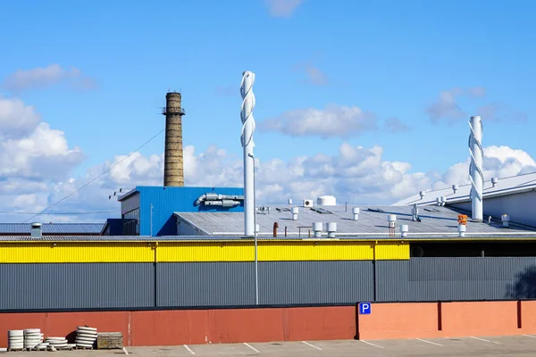 Wand eines modernen Fabrikgebäudes und Dach mit Abluft- und Lüftungsschornsteinen — Stockfoto