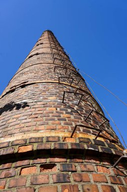 Mavi gökyüzüne karşı eski bir yüksek Fabrika baca.