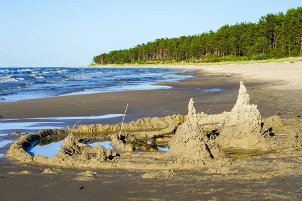 Un bambino costruì un castello di sabbia sulla riva del mare — Foto Stock