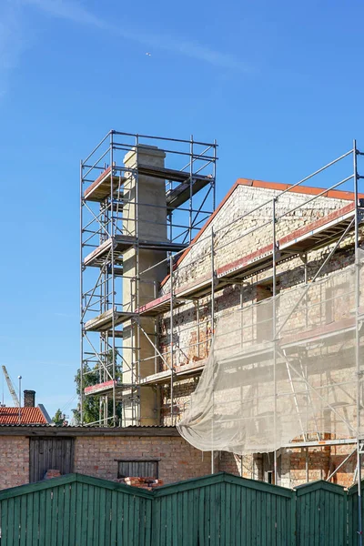 Schoorsteen herstelling tijdens renovatie van gebouwen, steigers rond de schoorsteen — Stockfoto