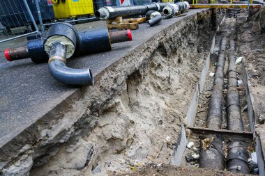 şehir caddesinde yeraltı ısıtma sistemi boruları değişimi