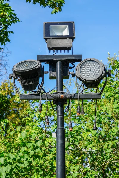 Projektörler ve birçok bağlantı kabloları ile parkta siyah bir sütun — Stok fotoğraf