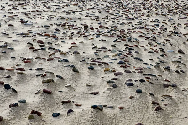 Sandstrand mit vielen kleinen Steinen, schöner Hintergrund — Stockfoto