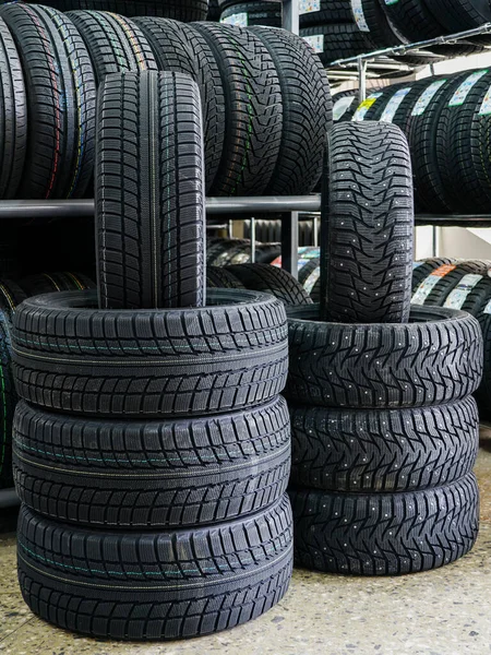 Nové zimní pneumatiky s hřeby a bez hřeby v obchodě s pneumatikami — Stock fotografie