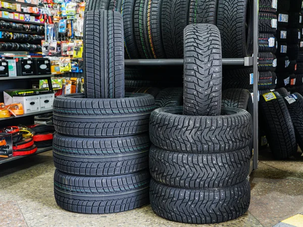 Nové zimní pneumatiky s hřeby a bez hřeby v obchodě s pneumatikami — Stock fotografie