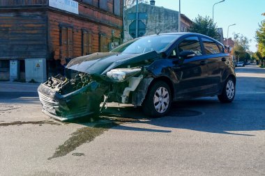 Şehir caddesinde bir trafik kazası, ön tarafı kırık bir araba.