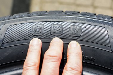 Yeni sezonun lastik kenarı üzerinde kar taneleri, şemsiye ve güneş resimleri