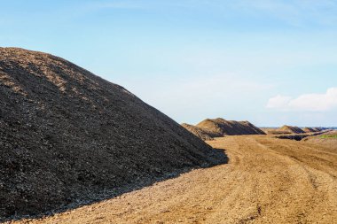 Mavi gökyüzü arka planına sahip bataklık manzarasında ticari turba çıkarma alanı