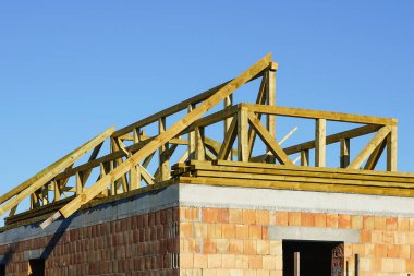 Mavi gökyüzü arka planında yeni bir ev çatısı inşaatı