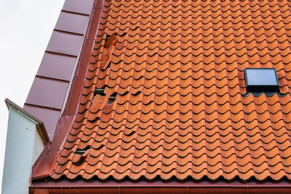 Damaged tile roof of a historical house with some missing roof tiles