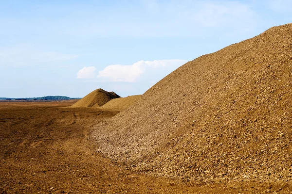 Mavi gökyüzü arka planına sahip bataklık manzarasında ticari turba çıkarma alanı