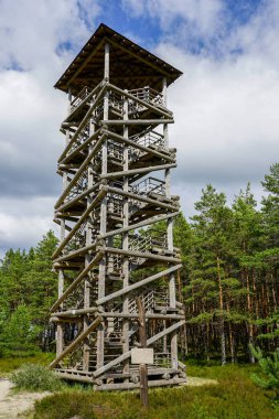 Mavi arka plandaki ahşap kütüklerden yapılmış yüksek gözetleme kulesi