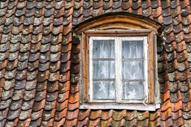 Romantik pencereli eski bir evin kiremit çatısı