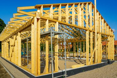 Güneşli bir günde görünür kirişler, iskeleler ve ICF temel sistemiyle inşaat halindeki kereste iskelesi.