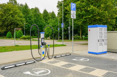 Belirlenmiş park yerleri ve güç kabinesi olan modern elektrikli araç şarj istasyonu, temiz ve sürdürülebilir şehir hareketliliğini teşvik ediyor