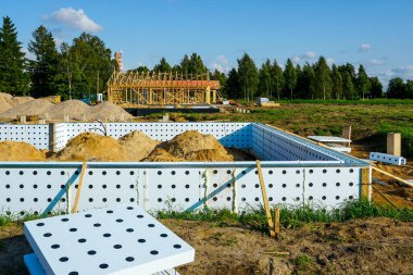 Yalıtımlı Beton Formu, toprak yığınları ve yerleşim alanındaki kereste çerçeveli ICF temel sistemi devam etmekte olan bir inşaat alanında