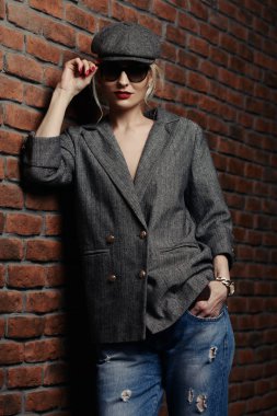 Gri ceket, şapka ve gözlük cinsel bir genç kadının portresi. Güzel akıllı kız. Güzellik, moda.